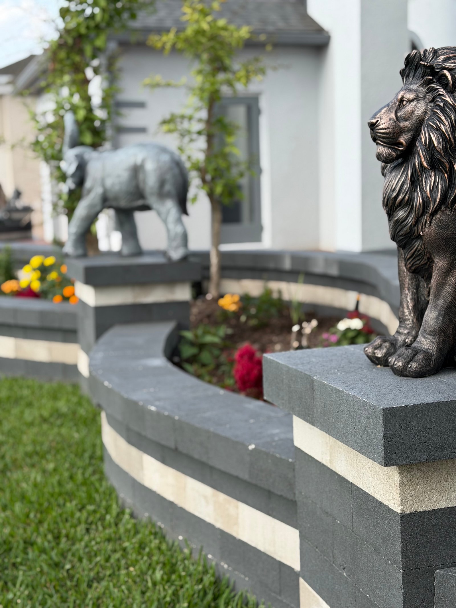 Bronze lion sculpture on a stacked retaining wall