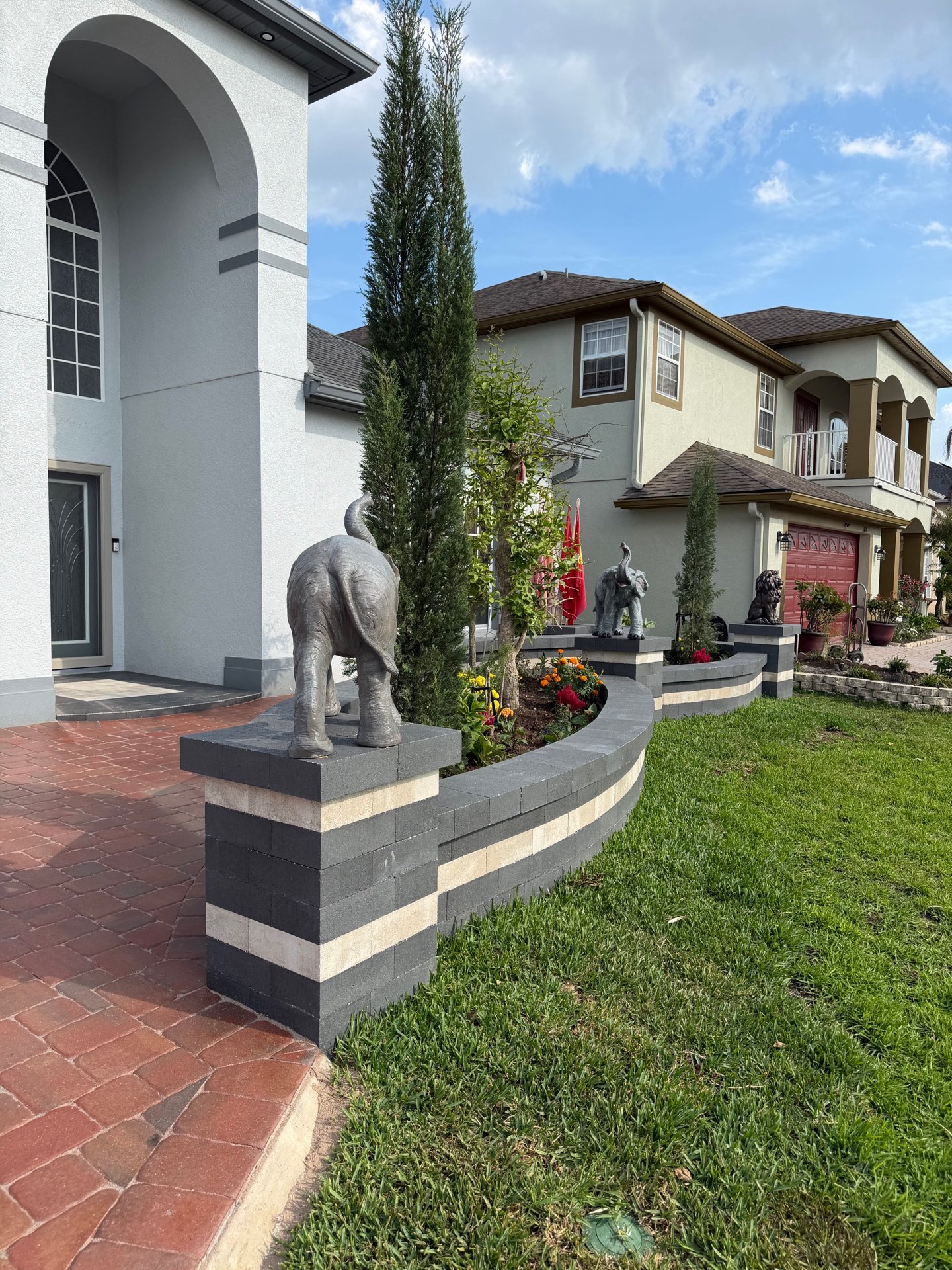 Curved retaining wall with elephant statue and flowers