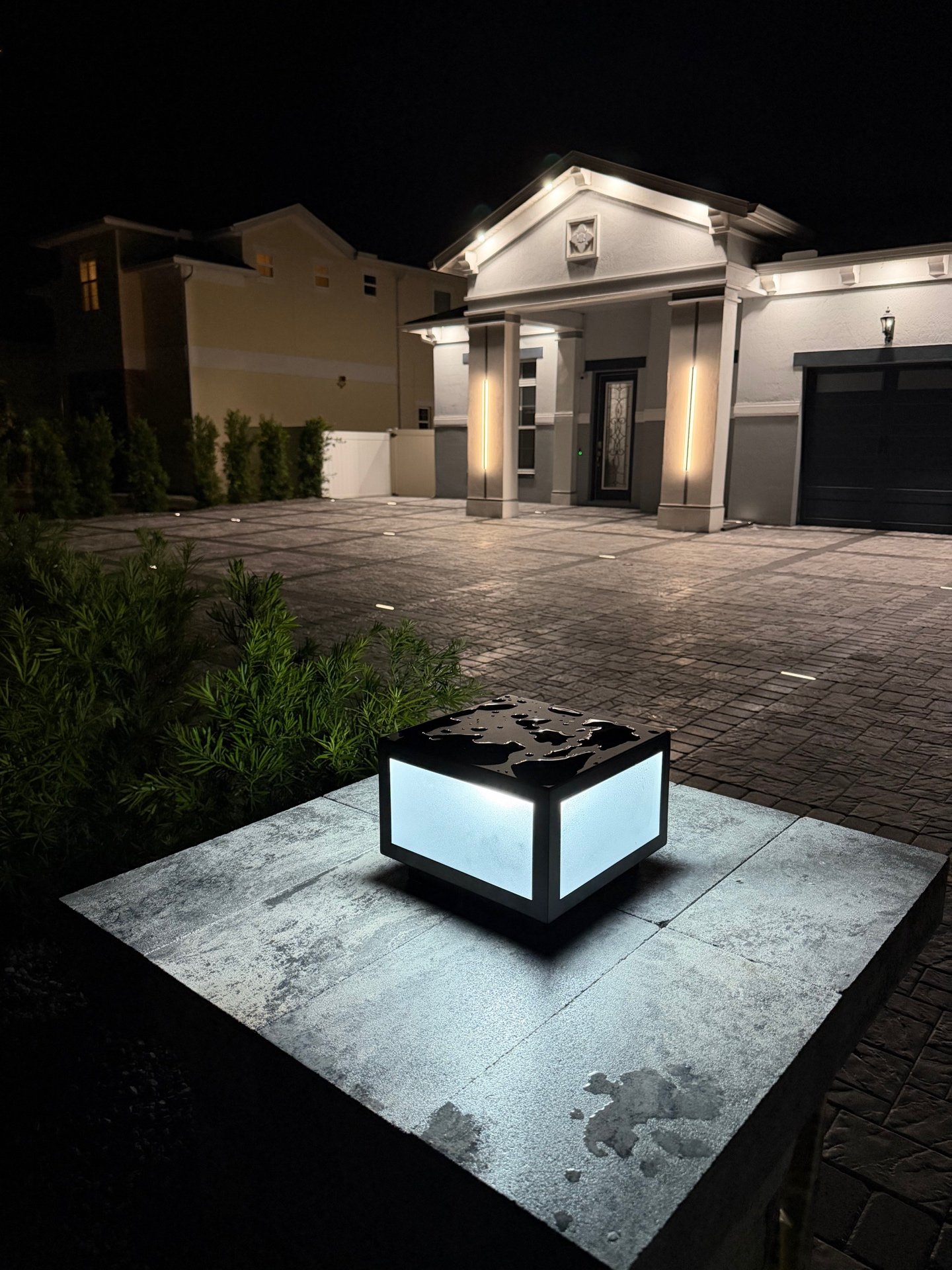 Illuminated driveway with custom pillar lighting at night