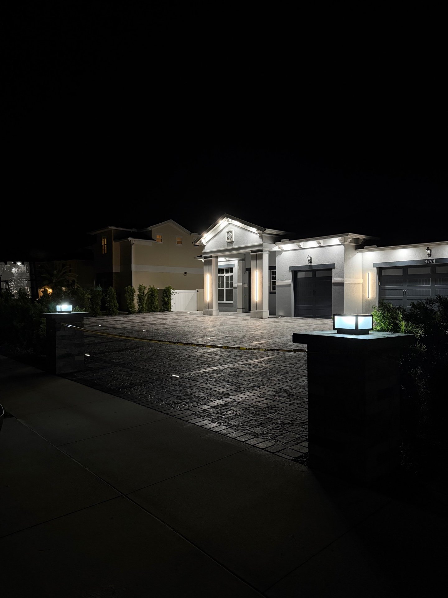 Home with paver driveway illuminated at night